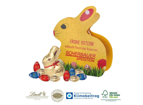 Werbe-Hase mit Goldhase und Schoko-Eier von Lindt auf Graspapier